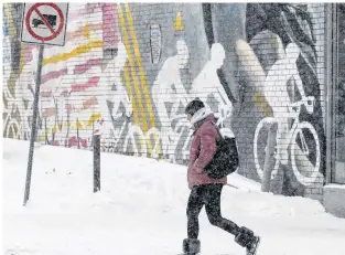  ?? CHRIS HELGREN/REUTERS ?? A woman passes a sporting goods store during a snow storm in Toronto, Ont., Jan. 18.