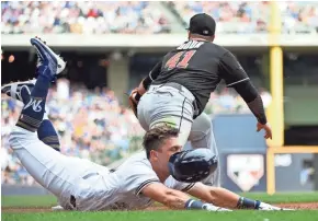  ?? BENNY SIEU / USA TODAY SPORTS ?? Brewers second baseman Hernan Perez beats out an infield hit in the fourth inning during the game against the Marlins on Sunday at Miller Park.