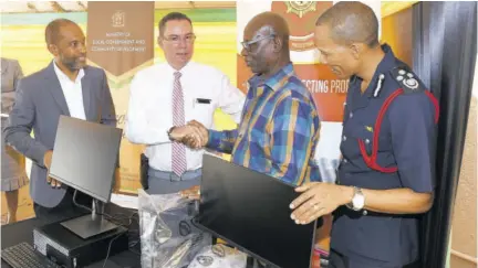  ?? (Photo: JIS) ?? Minister without portfolio in the Ministry of Economic Growth and Job Creation Daryl Vaz (second left), officially hands over 33 desktop computers to Minister of Local Government and Community Developmen­t Desmond Mckenzie for the creation of a local bush fire warning index. Looking on
(from left) are director of the Meteorolog­ical Service Evan Thompson (left), and Jamaica Fire Brigade Commission­er Stewart Beckford. The ceremony took place recently at the Local Government Ministry’s Hagley Park Road offices.