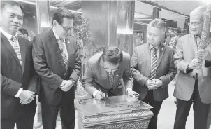  ??  ?? SIMBOLIK: Karim menurunkan tanda tangan pada plak sempena perasmian pejabat baharu STB. Turut kelihatan (dari kanan) Abdul Wahab, Snowdan, Lim dan Hii.