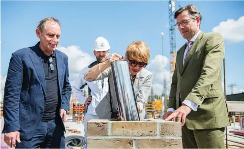  ?? Foto: dpa/Wolfram Kastl ?? Ministerin Martina Münch (SPD/M.) senkt die Zeitkapsel in den Grundstein, neben ihr Architekt Volker Staab (l.) und SPSG-Chef Hartmut Dorgerloh.