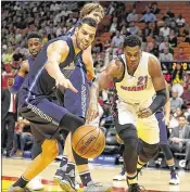  ?? PEDRO PORTAL / MIAMI HERALD ?? Hassan Whiteside chases the ball along with Dallas’ Salah Mejri during the Heat’s 99-95 victory Thursday night. The Miami center had 13 points and 8 rebounds.