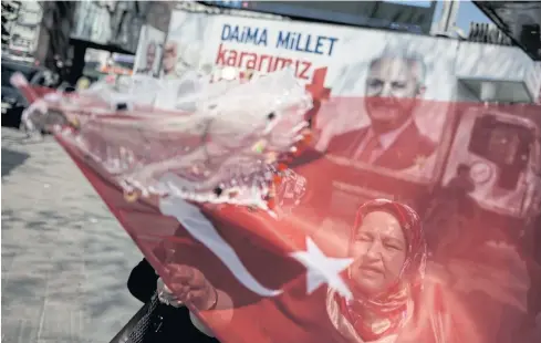  ??  ?? DIVIDED: A supporter of the ‘yes’ vote waves a flag during campaignin­g in Istanbul, ahead of today’s referendum.