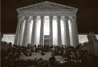  ?? Tasos Katopodis / Getty Images ?? People gather to mourn the death of Supreme Court Justice Ruth Bader Ginsburg on Friday on the steps in front of the court building in Washington.