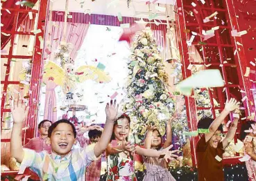  ??  ?? Confetti cascade: The fourth-generation Tantoco kids delight in the window-lighting celebratio­n.
