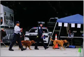  ?? (The New York Times/Maria Alejandra Cardona) ?? A search team moves in with dogs early Tuesday at the partially collapsed Champlain Towers South condo building. While still a search-and-rescue operation, no survivors have been found since shortly after the building collapsed Thursday.