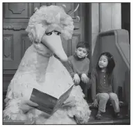  ?? AP/MARK LENNIHAN ?? Big Bird reads to Connor Scott and Tiffany Jiao on an episode of Sesame Street filmed in New York. For years the series has been part of a study on the connection between intelligen­ce and television consumptio­n.