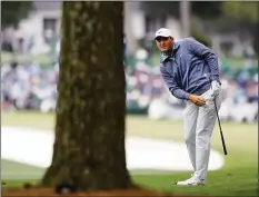  ?? Curtis Compton / Associated Press ?? Scottie Scheffler watches his second shot on the first fairway during the third round of the Masters on Saturday.