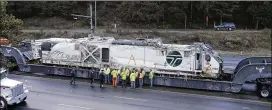  ?? ELAINE THOMPSON / AP ?? Washington State Patrol officers and workers gather Wednesday next to an Amtrak engine being removed from the site of a deadly crash in DuPont, Wash. Three people were killed when the train plunged off an overpass Monday.