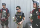  ??  ?? Skydivers carry white roses as they prepare to jump in the honor of two men who died in a tandem parachutin­g accident at the Lodi Parachute Center on Aug. 6.