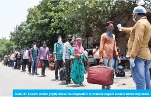  ??  ?? GUJARAT: A health worker (right) checks the temperatur­e of stranded migrant workers before they board on special busses to return to their hometowns during a government-imposed nationwide lockdown as a preventive measure against the COVID-19 coronaviru­s. — AFP