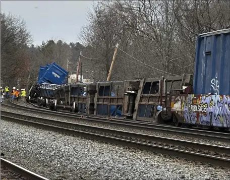  ?? RODRIQUE NGOWI — THE ASSOCIATED PRESS ?? Officials work at the scene of a freight train derailment Thursday in Ayer. No hazardous materials were being hauled, according to the local fire department.