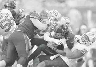  ??  ?? Miami quarterbac­k D’Eriq King is sacked by North Carolina linebacker Tomon Fox and Jeremiah Gemmel during the first half Saturday at Hard Rock Stadium.
MICHAEL LAUGHLIN | SOUTH FLORIDA SUN SENTINEL