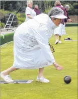  ??  ?? Joy Wright, left, in action during the ladies’ opening day, and right, one member improvises to keep the rain at bay