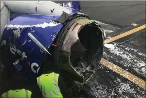  ?? AP/AMANDA BOURMAN ?? The engine of a Southwest Airlines plane is inspected on a runway at the Philadelph­ia Internatio­nal Airport where the aircraft made an emergency landing Tuesday.