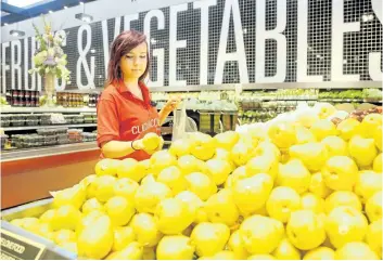  ?? JULIE OLIVER/OTTAWA CITIZEN ?? Personal Shopper Rachel Fairservic­e picks out groceries in the produce section for the click-and-collect service at the Barrhaven Loblaws store. Loblaws is observing the emerging home-delivery service offered by other companies.