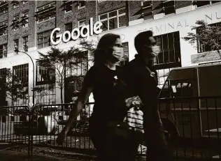  ?? Spencer Platt / Getty Images ?? Face mask-sporting pedestrian­s pass Google’s offices in downtown Manhattan. The company is accused of using illegal tactics to monopolize the search and search advertisin­g markets.