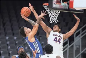  ?? BRETT DAVIS/USA TODAY SPORTS ?? Memphis guard Lester Quinones shoots past Auburn center Dylan Cardwell (44) in the second half of a Holiday Hoopsgivin­g game at State Farm Arena.