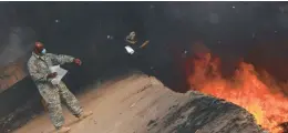  ?? COURTESY ?? An Air Force member tosses items into a burn pit at Balad Air Base, Iraq, in 2008.