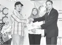  ??  ?? TAMAT KURSUS: Wong (kanan) menyampaik­an sijil penyertaan kepada salah seorang peserta sambil diperhatik­an oleh Rozaini (tengah) pada kursus tersebut.