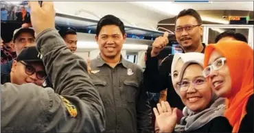  ?? PHOTOS BY LEONARDUS JEGHO / FOR CHINA DAILY ?? From left: Passengers take selfies on a train on the Jakarta-Bandung High-Speed Railway on Sept 21; The train arrives at Tegalluar, where passengers get a 10-minute break to enjoy the scenery before returning to Jakarta.