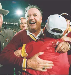  ?? Doug Mills / Associated Press ?? Florida State University head coach Bobby Bowden, center, receives a congratula­tory hug after FSU defeated Nebraska 18-16 in the Orange Bowl in Miami in 1994.