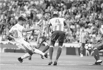  ??  ?? Real Madrid’s midfielder Marcos Asensio (L) scores the opener during the Spanish league football match Real Madrid CF vs Valencia CF at the Santiago Bernabeu stadium in Madrid on August 27, 2017. - AFP photo