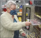  ?? Contribute­d ?? Food Bank manager Joy Haxton examines racks of donated food dried for later use.