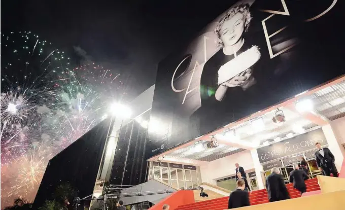  ??  ?? Ascent to movie heaven: Fireworks lighting up the sky over the ‘Palais des Festivals’ with a giant canvas of the official poster of the 65th Cannes Film Festival featuring US actress Marilyn Monroe in the background. The 10-day film festival, which...