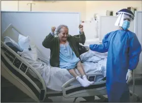  ?? (AP/Natacha Pisarenko) ?? Blanca Ortiz, 84, celebrates after learning she will be dismissed from the Eurnekian Ezeiza Hospital on the outskirts of Buenos Aires, Argentina, on Aug. 13, several weeks after being admitted with covid-19. Photograph­er Natacha Pisarenko said the moment was one of the few she witnessed in months of covering covid-19 in which doctors and nurses allowed themselves to feel joy. “The moment made all of us in the room with her laugh and feel hopeful again,” Pisarenko said. “It was the brightest moment for me while covering such a heavy story.”