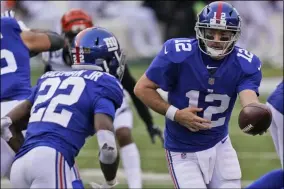  ?? BRYAN WOOLSTON - THE ASSOCIATED PRESS ?? New York Giants quarterbac­k Colt McCoy (12) hands off the ball to running back Wayne Gallman (22) during the second half of an NFL football game against the Cincinnati Bengals, Sunday, Nov. 29, 2020, in Cincinnati.