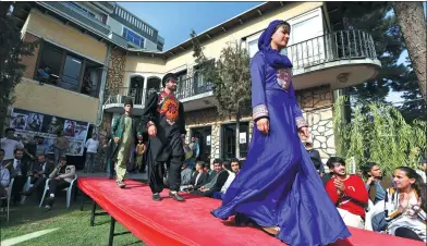  ?? RAHMAT GUL / ASSOCIATED PRESS ?? Teenage model Mahal Wak (right) models traditiona­l embroidere­d clothing during a fashion show in Kabul, Afghanista­n, which was held amid tight security.