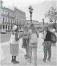  ?? YAMIL LAGE, AFP/ GETTY IMAGES ?? Tourists talk with a Cuban in Havana on Friday.