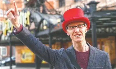  ?? (AP/Alastair Grant) ?? Neil Maxfield, who runs a theater walking tour that takes about two hours and visits some 14 London theaters, gestures outside the Palace Theater in London. One of those sidelined when the pandemic forced theaters to close was Maxfield, who turned his love of musicals into a job leading walking tours of London’s West End.