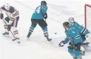  ?? AP ?? Edmonton Oilers centre Leon Draisaitl, left, scores the winner against the Sharks during overtime.