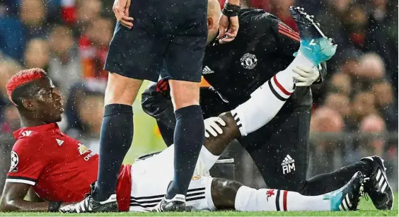  ?? — Reuters ?? You can’t carry on: Manchester United’s Paul Pogba receiving medical attention after sustaining an injury in the Champions League Group A match against Basel at Old Trafford on Tuesday.