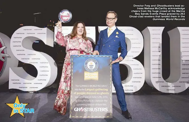  ??  ?? Only in STAR Director Feig and Ghostbuste­rs lead actress Melissa McCarthy acknowledg­e cheers from the huge crowd at the Marina Bay Sands Events Plaza graced by 263 Ghost-clad revelers that landed them in the Guinness World Records