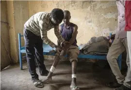  ?? NARIMAN EL-MOFTY AP ?? Tewodros Tefera checks the wounds of Guesh Tesla, a 54-year-old carpenter and Tigrayan survivor from Rawyan, Ethiopia, at a refugee center in eastern Sudan on Dec. 15.