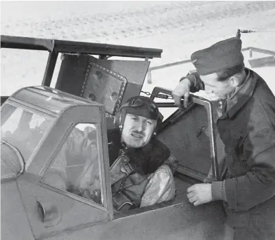  ??  ?? A mechanic assists Walther Dahl to strap himself into the cockpit of his Bf 109 G. Note the armor plate, which protected the pilot’s head from fire from the rear, and the yellow octane triangle just forward of the fuselage
Balkenkreu­z (cross). (Photo courtesy of EN Archive collection)