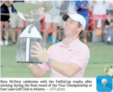  ?? — AFP photo ?? Rory McIlroy celebrates with the FedExCup trophy a er winning during the final round of the Tour Championsh­ip at East Lake Golf Club in Atlanta.