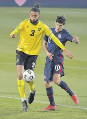  ??  ?? Jamaica defender Michael Hector (left) gets the better of USA midfielder Christian Pulisic.