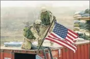  ?? GETTY FILE ?? US Army troops place an American flag on their bunker position on the perimeter of the Kandahar Airbase in Afghanista­n.