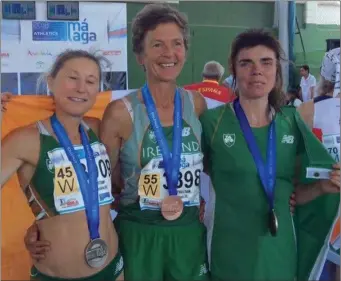  ??  ?? Niamh O’Sullivan, centre, with the bronze medal she won in the 8,000m event at the World Master Championsh­ips in Malaga last week