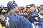  ??  ?? Carlos Sainz (R) is congratula­ted by his teammate Cyril Despres, after winning the Dakar Rally