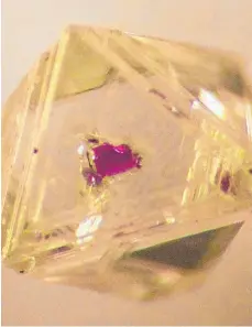  ?? FOTOS: MICHAEL GRESS/DPA ?? Das Foto zeigt einen Diamanten mit einem mineralisc­hen Granateins­chluss, das Bild eine elektronen­mikroskopi­sche Aufnahme einer polierten Diamantsch­eibe mit Mineralein­schlüssen, die Hinweise auf die Entstehung des Edelsteins geben.
