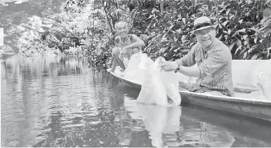  ??  ?? TANGGUNGJA­WAB: TR Antau (kanan) melepaskan anak-anak ikan dalam Sungai Sekabai.