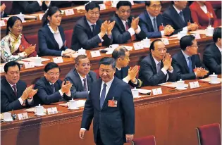  ??  ?? Delegates applaud as Chinese President Xi Jinping walks to his seat Sunday after casting his vote for an amendment to China’s constituti­on that will abolish term limits on the presidency and enable him to rule indefinite­ly, during a plenary session of...