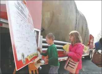  ?? The Sentinel-Record/Richard Rasmussen ?? SIGNING UP: Allen Wetzler, 6, left, and Lorelei Wetzler, 8, of Hot Springs, on Monday sign a signature board set up next to The Famous Idaho Potato Tour at Hill Wheatley Plaza.