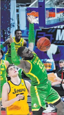  ?? Paul Sancya The Associated Press ?? Oregon’s Franck Kepnang, right, slices inside against Iowa’s Luka Garza for a dunk in the second half of Monday’s 95-80 victory.