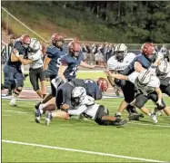  ?? Tim Godbee ?? Calhoun defenders swarm a Woodstock runner in an overwhelmi­ng 56-16 road win.